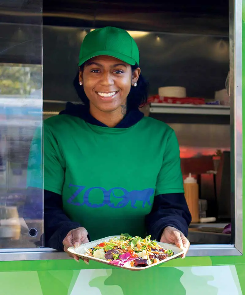 Employee inside of food trucking, passing food through window