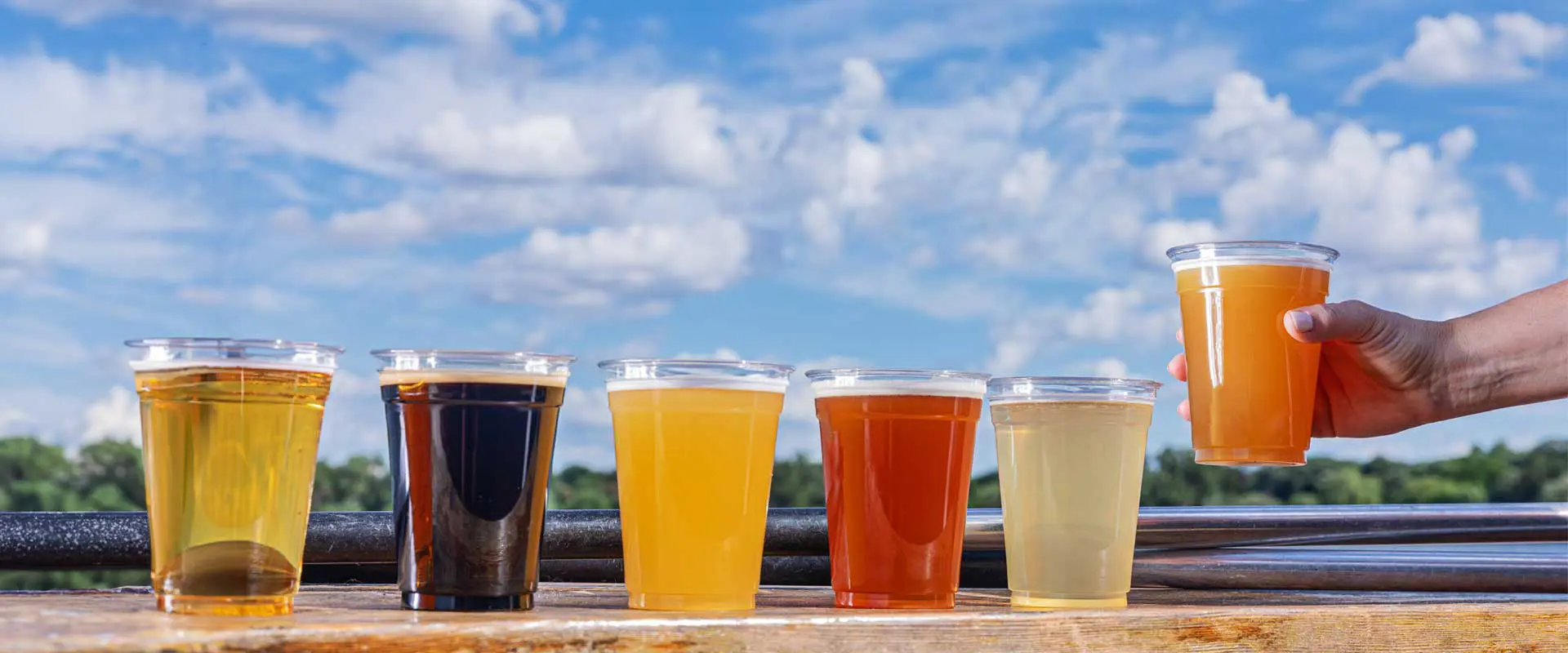 Beer on a wooden table with hand reaching in