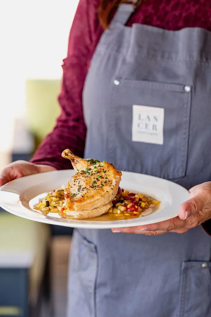 Employee holding plate chicken dish