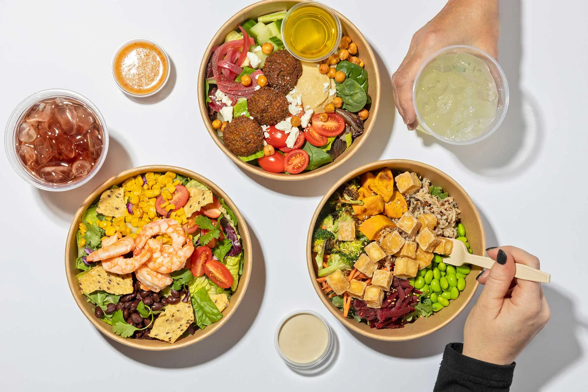 Overhead shot of salad bowls and beverages