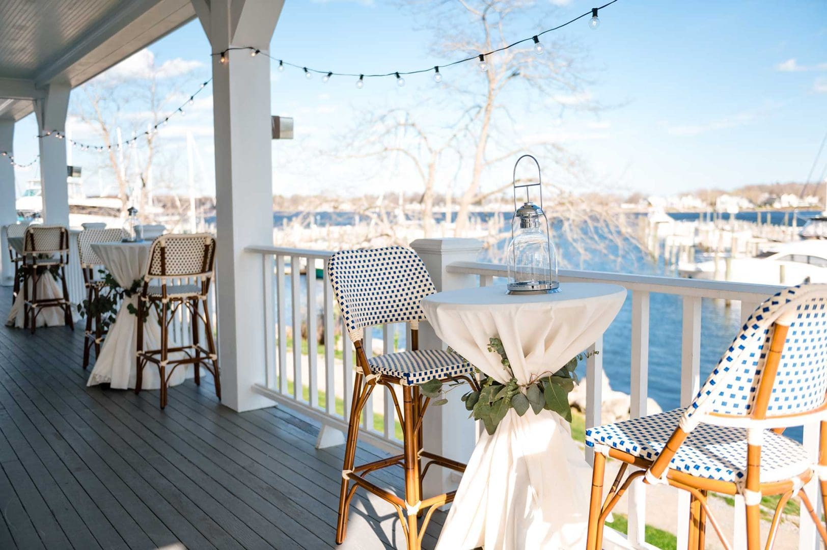 Shot of cocktail tables on porch overlooking water